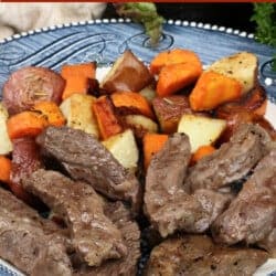 slices of cooked steak, diced carrots, and potatoes on a blue plate next to a green salad