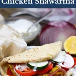 chicken shawarma on a plate next to tzatziki sauce in a bowl.