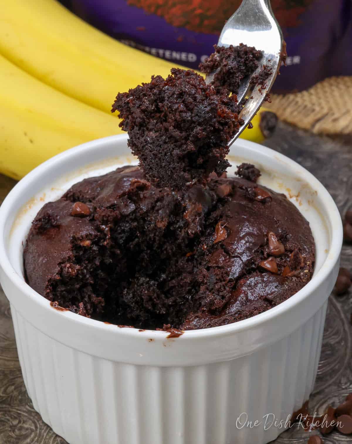 chocolate banana bread on a fork held over the baking dish.