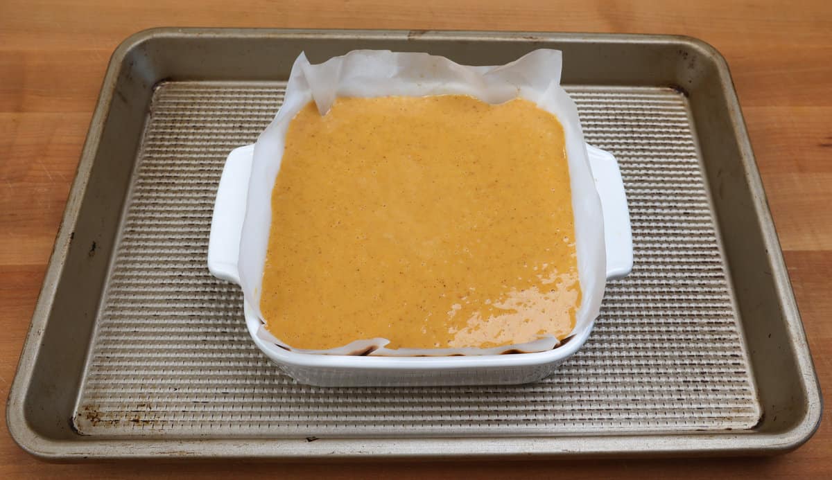 an unbaked pumpkin pie on a rimmed baking sheet.