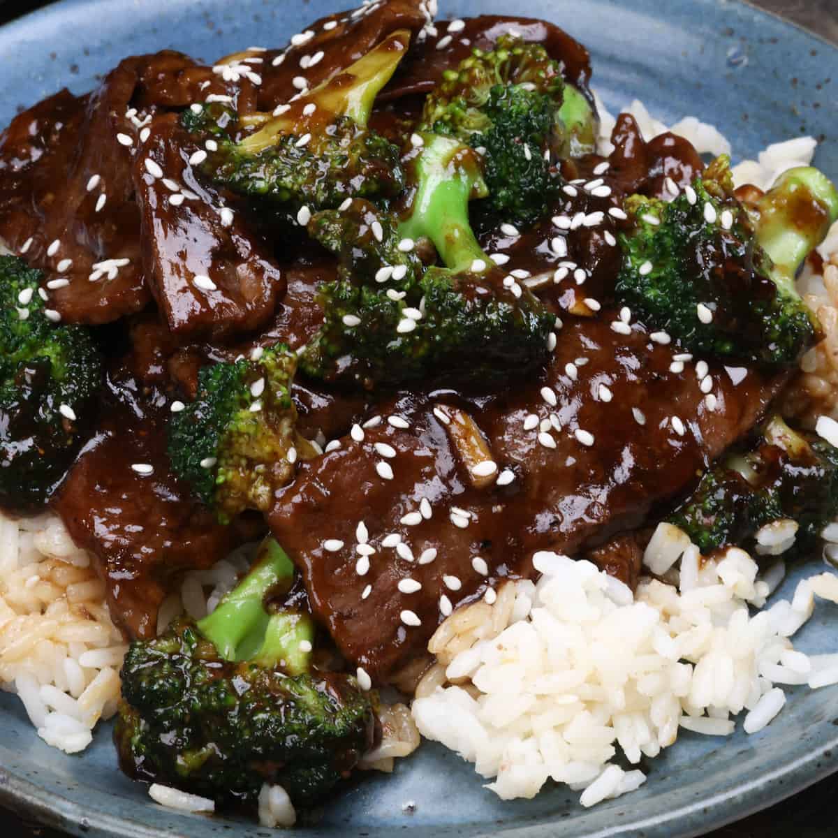 beef and broccoli topped with sesame seeds over white rice.