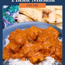 chicken tikka masala over white rice next to a plate of naan.