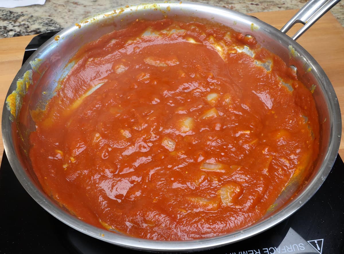 tomato sauce with onions simmering in a skillet.