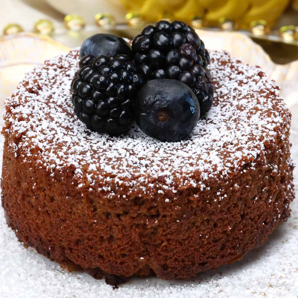 a single serving chocolate lava cake topped with powdered sugar and fresh berries.