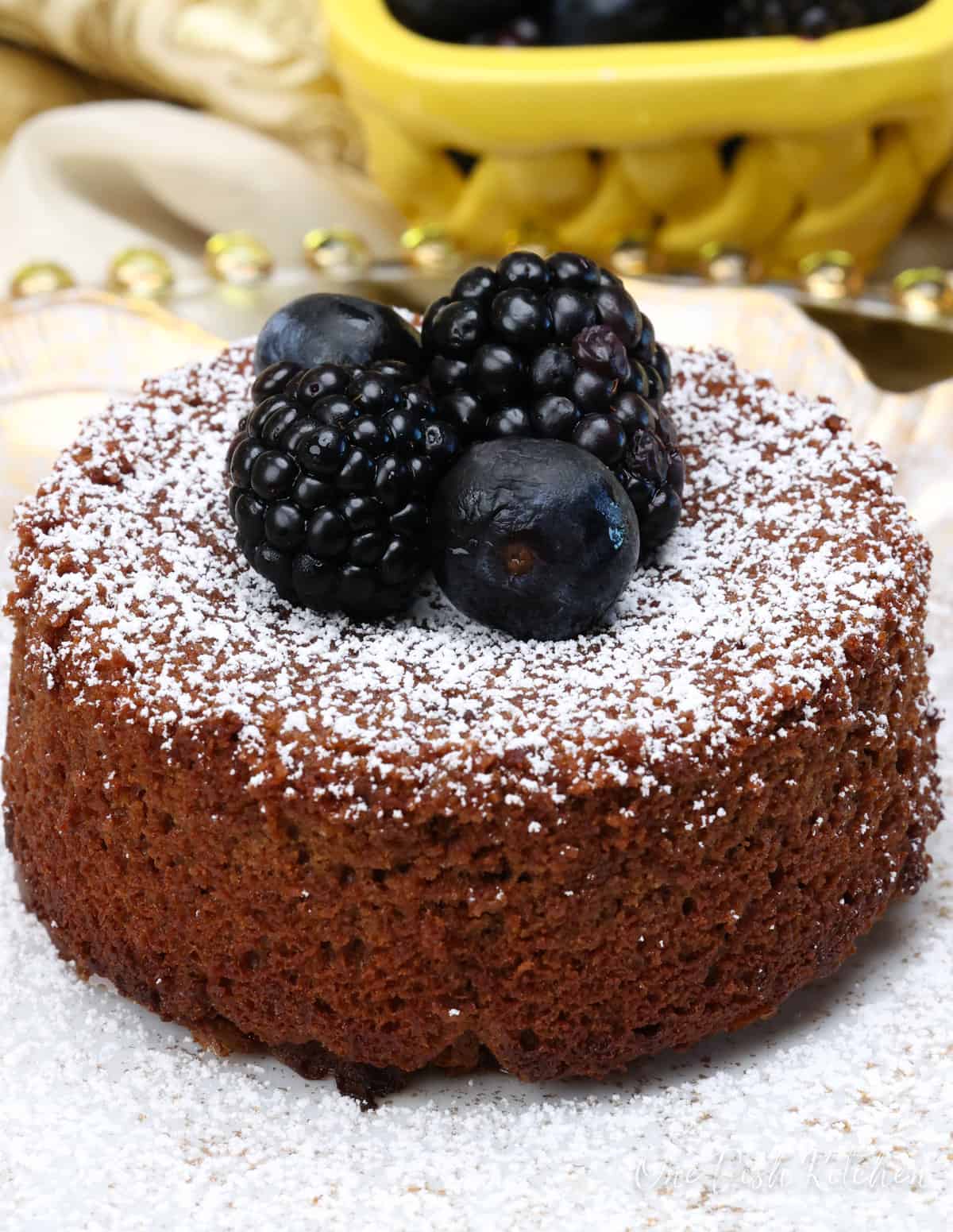 chocolate lava cake topped with berries and powdered sugar on a plate.