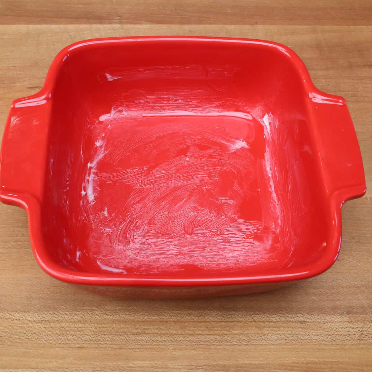 a lightly buttered 5 inch square baking dish on a kitchen counter.