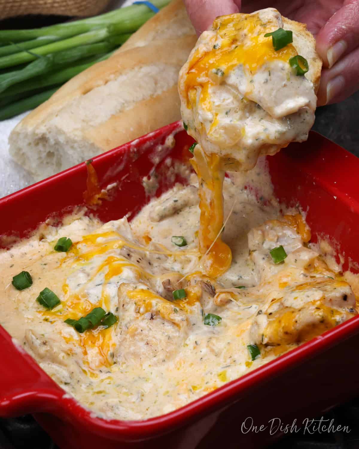 creamy crack chicken in a dish with a piece of bread on the side.