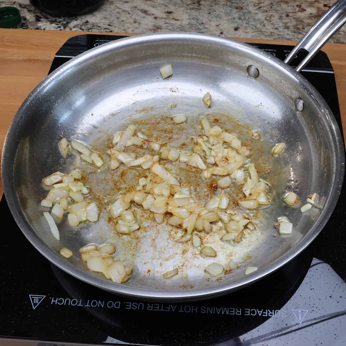 onions and garlic cooking together in a skillet.