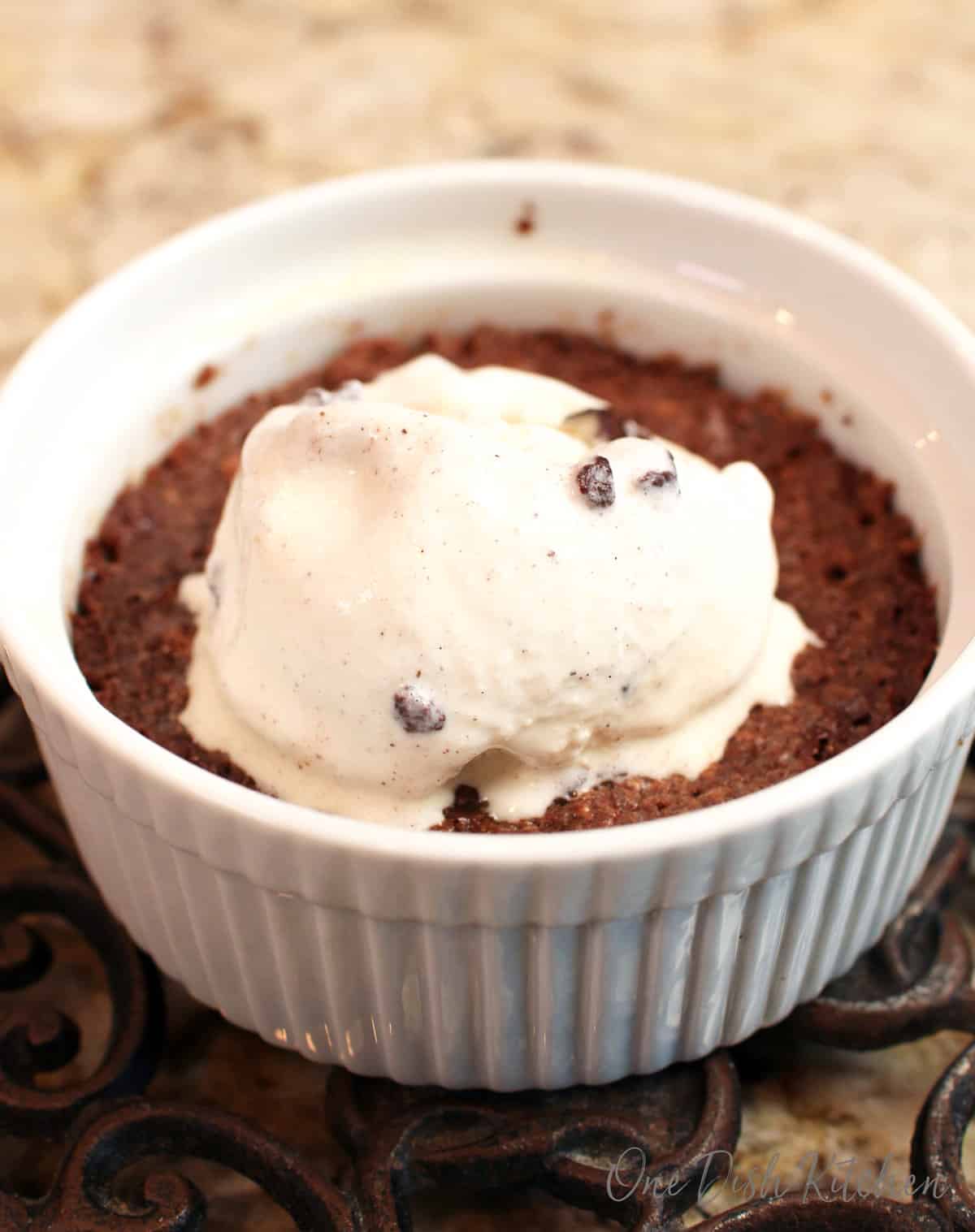 a single brownie in a ramekin topped with ice cream.