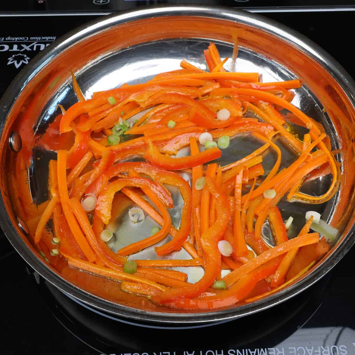 lo mein vegetables cooking in a skillet.