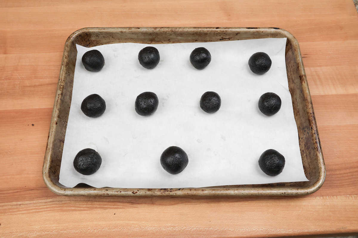 oreo cookie ball dough on a wax paper-lined cookie sheet.