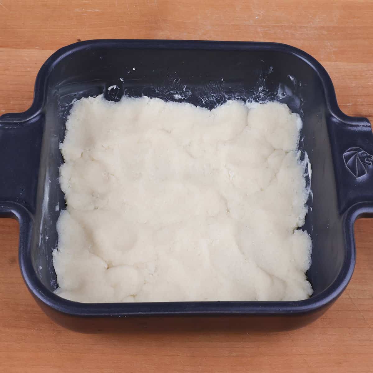 an unbaked shortbread pie crust in a small baking dish.
