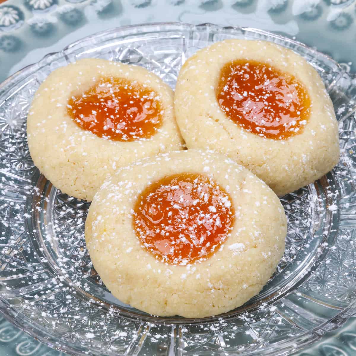 Thumbprint Cookies dusted with powdered sugar on a plate.