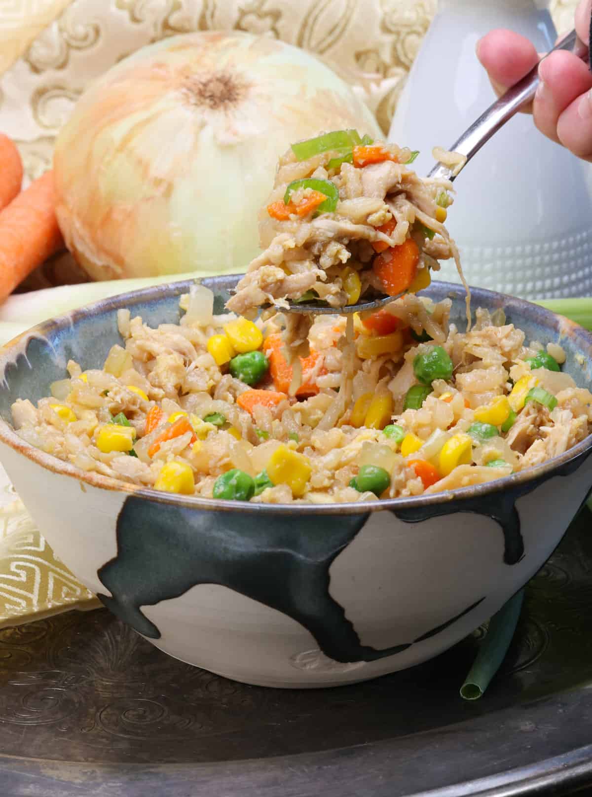 a fork over a bowl of chicken fried rice.
