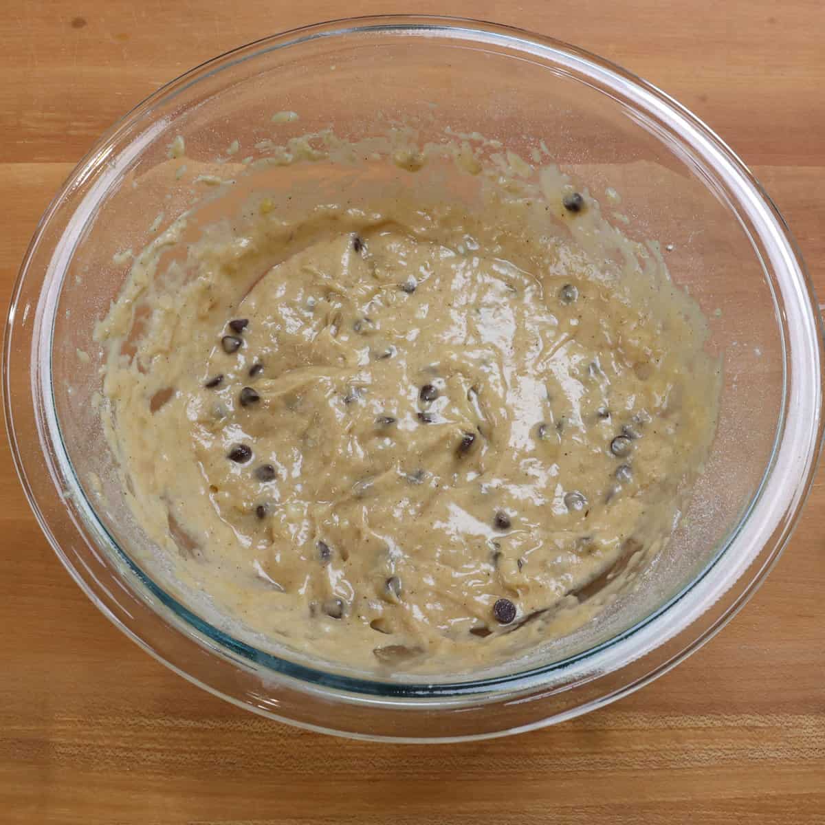 chocolate chips folded into banana bread batter in a mixing bowl.