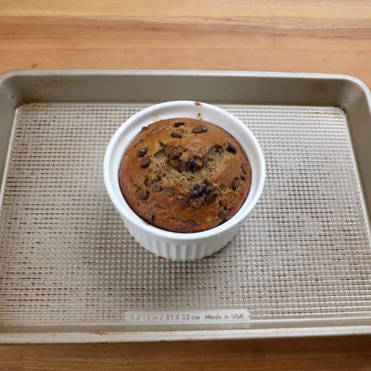 one small baked banana bread with chocolate chips on a baking sheet.