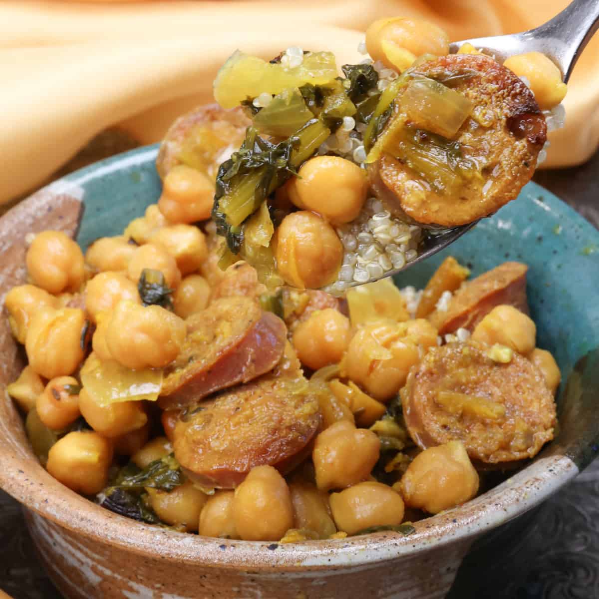 a bowl of crockpot chickpeas with sausage and greens.