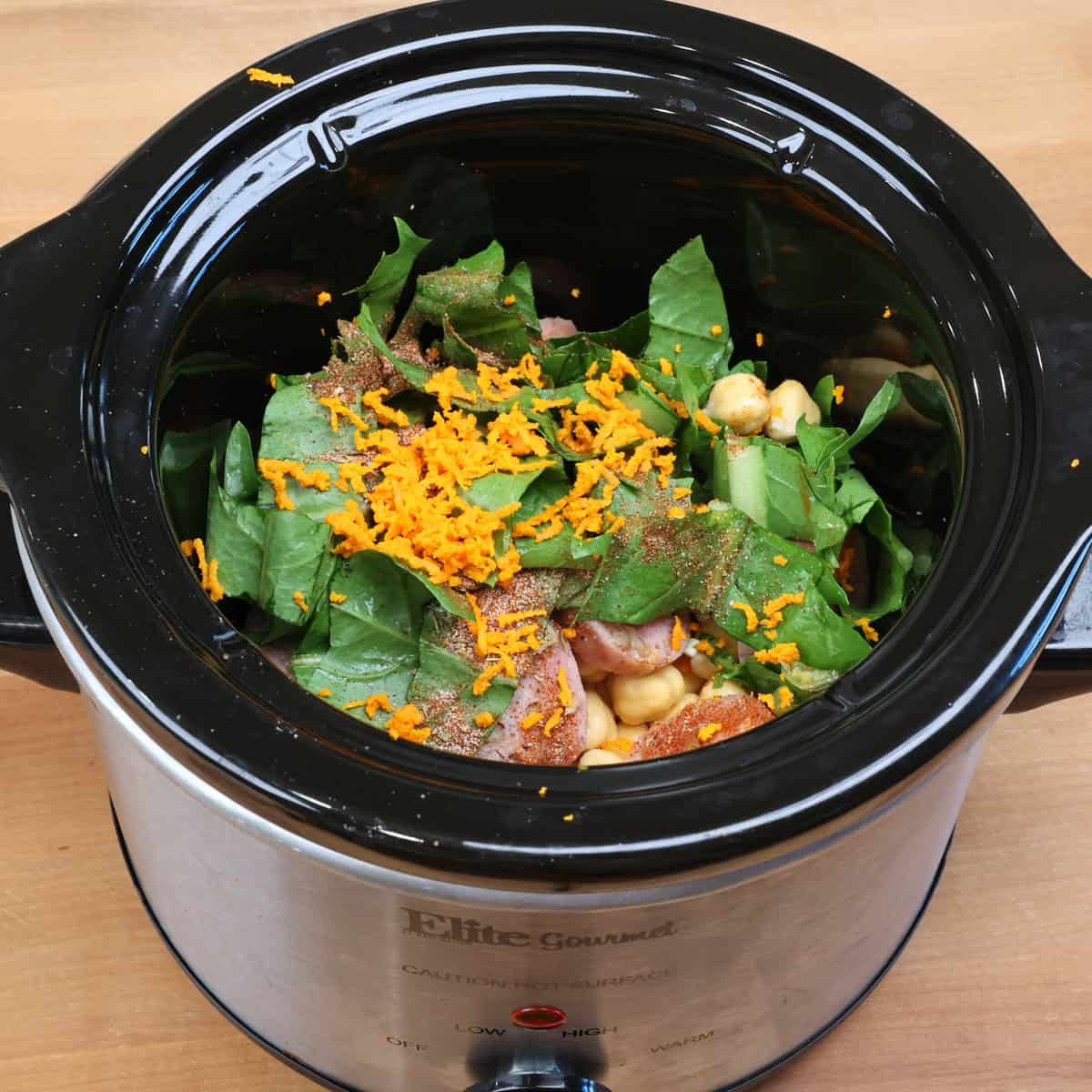 chickpeas, sausage, greens, seasonings, and turmeric in a small slow cooker.