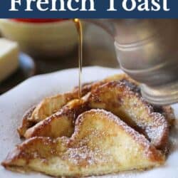 Four slices of french toast on a white plate with powdered sugar on top and syrup being poured.
