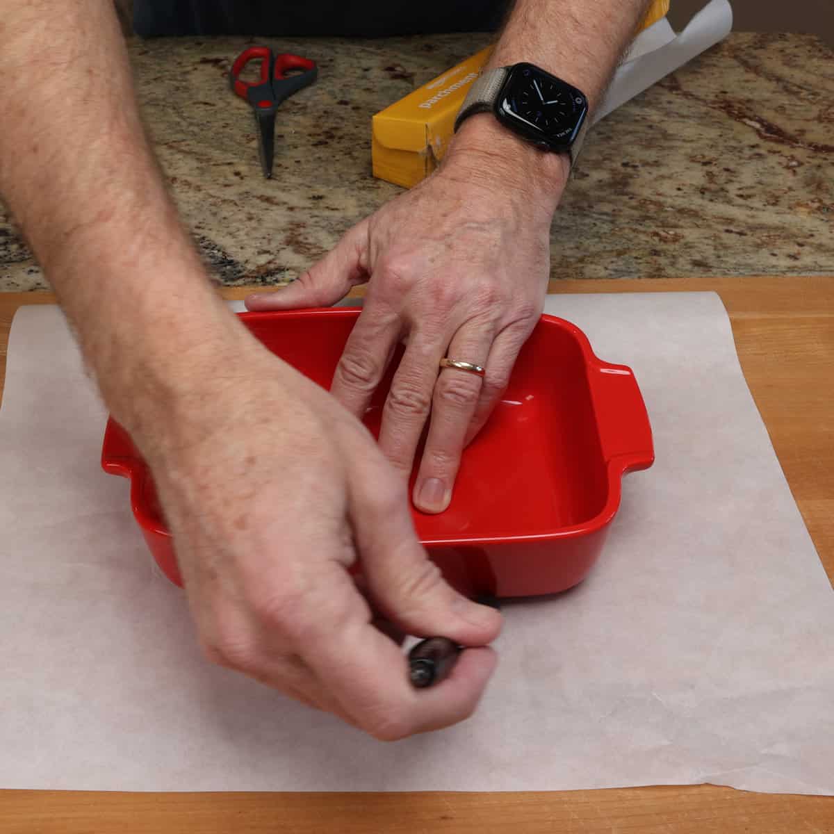 tracing a baking dish on a sheet of parchment paper.