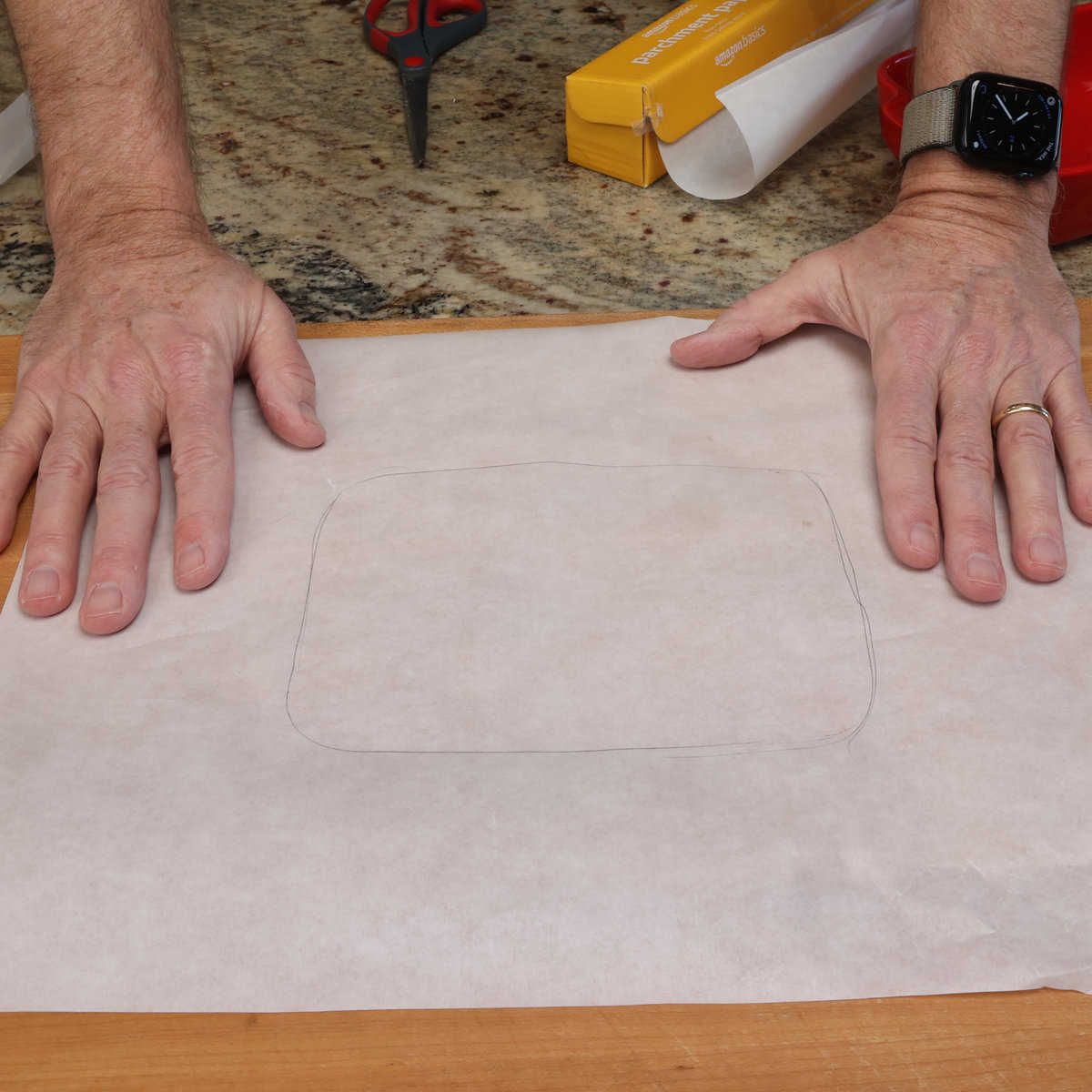 cutting the parchment paper to fit the baking dish.