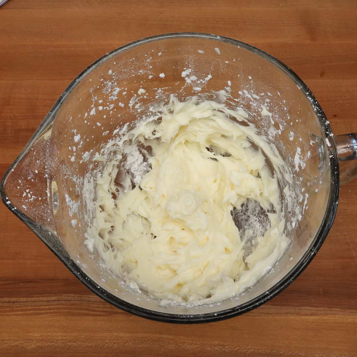 cream cheese, butter, powdered sugar, and almond extract mixed together in a mixing bowl.