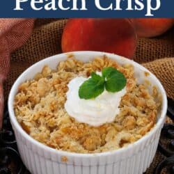 Peach crisp with whipped topping in a white ramekin.