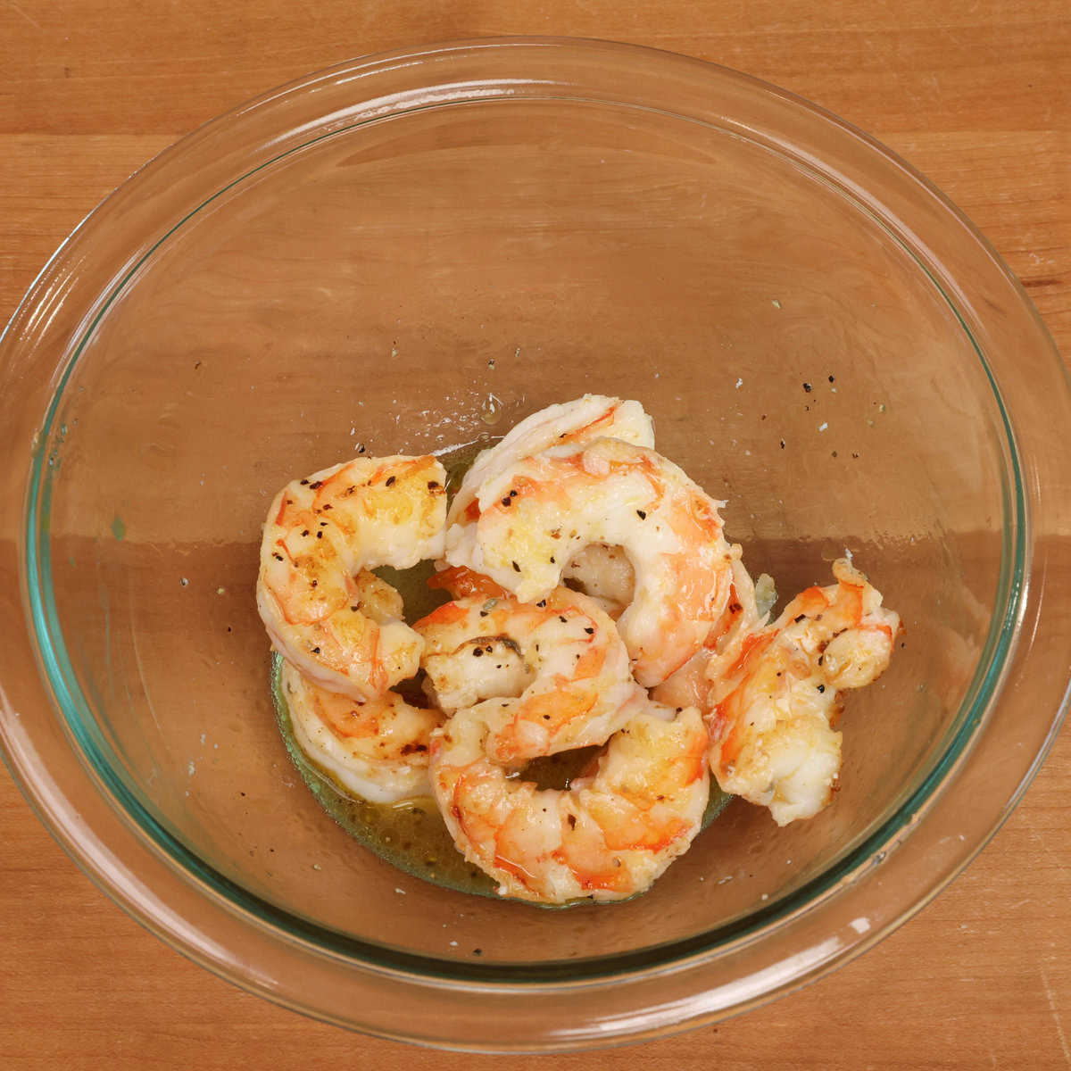 shrimp in a bowl tossed with dressing.