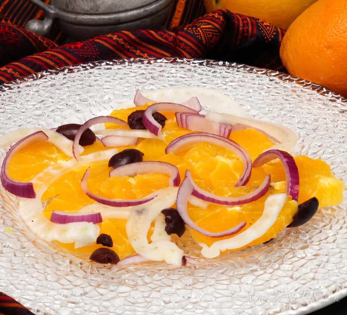 orange slices, red onions, fennel, and kalamata olives on a white plate.