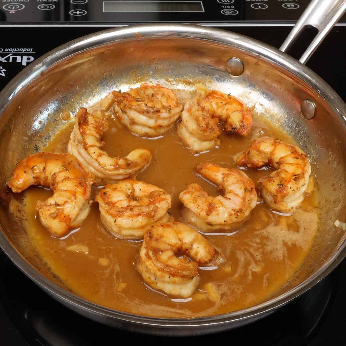 BBQ shrimp cooking in a skillet.