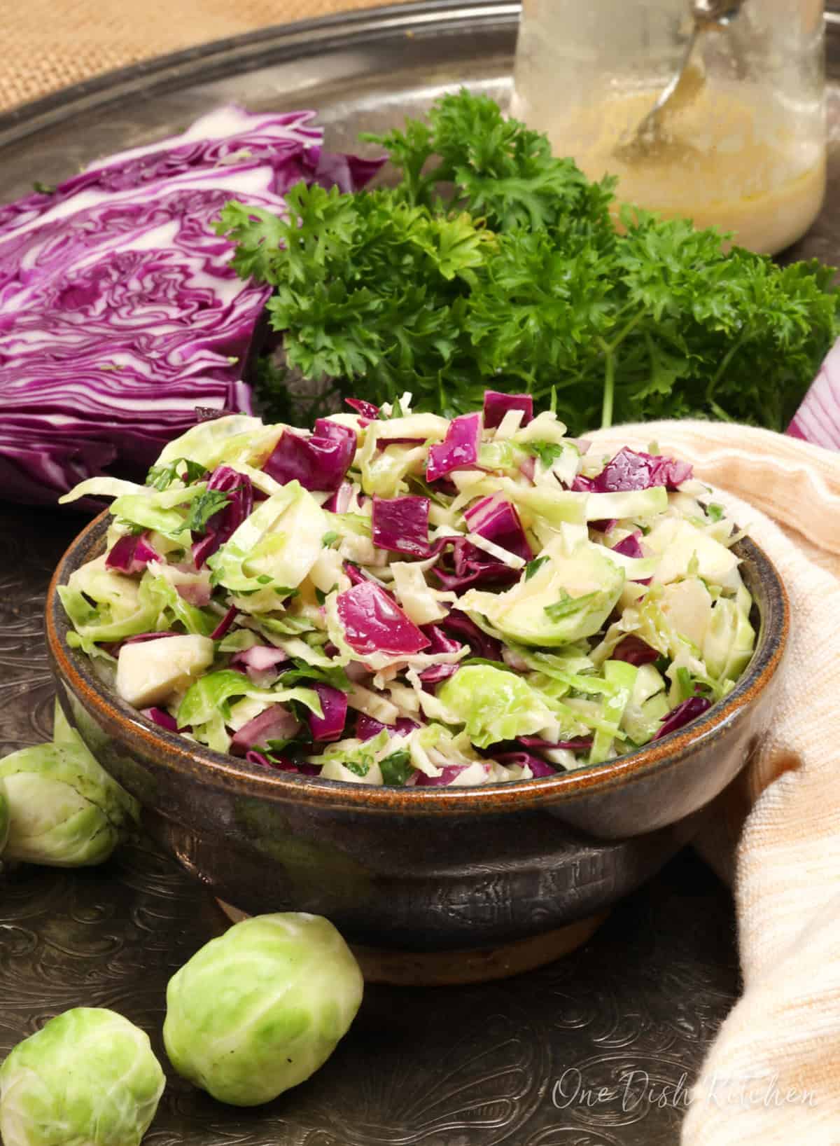 a shaved brussels sprouts salad in a purple bowl.