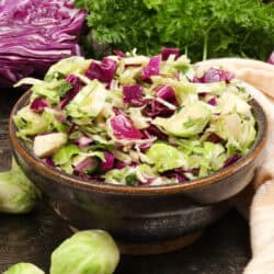 a shaved brussels sprouts salad in a purple bowl.