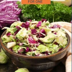 a shaved brussels sprouts salad in a purple bowl.