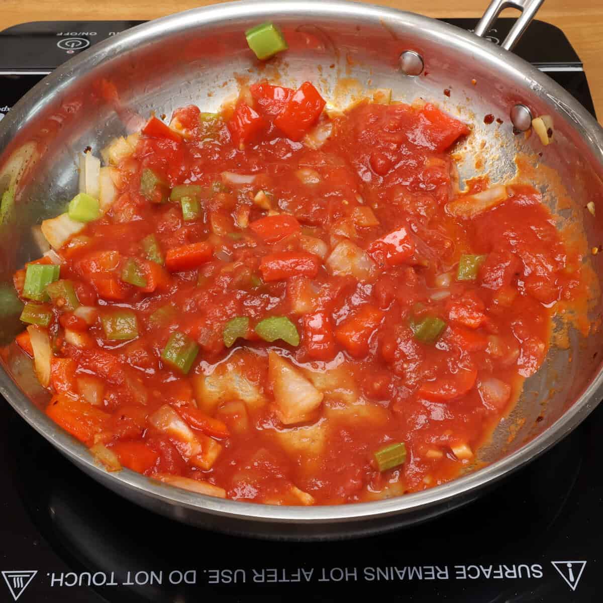 tomatoes and vegetables simmering in a skillet.