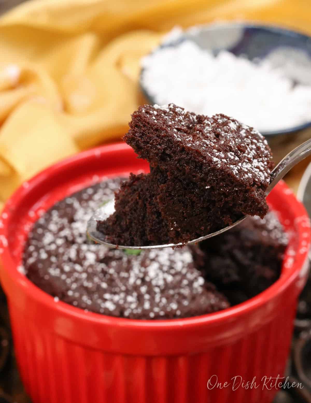 a mini chocolate cake with a fork on the side of the dish.