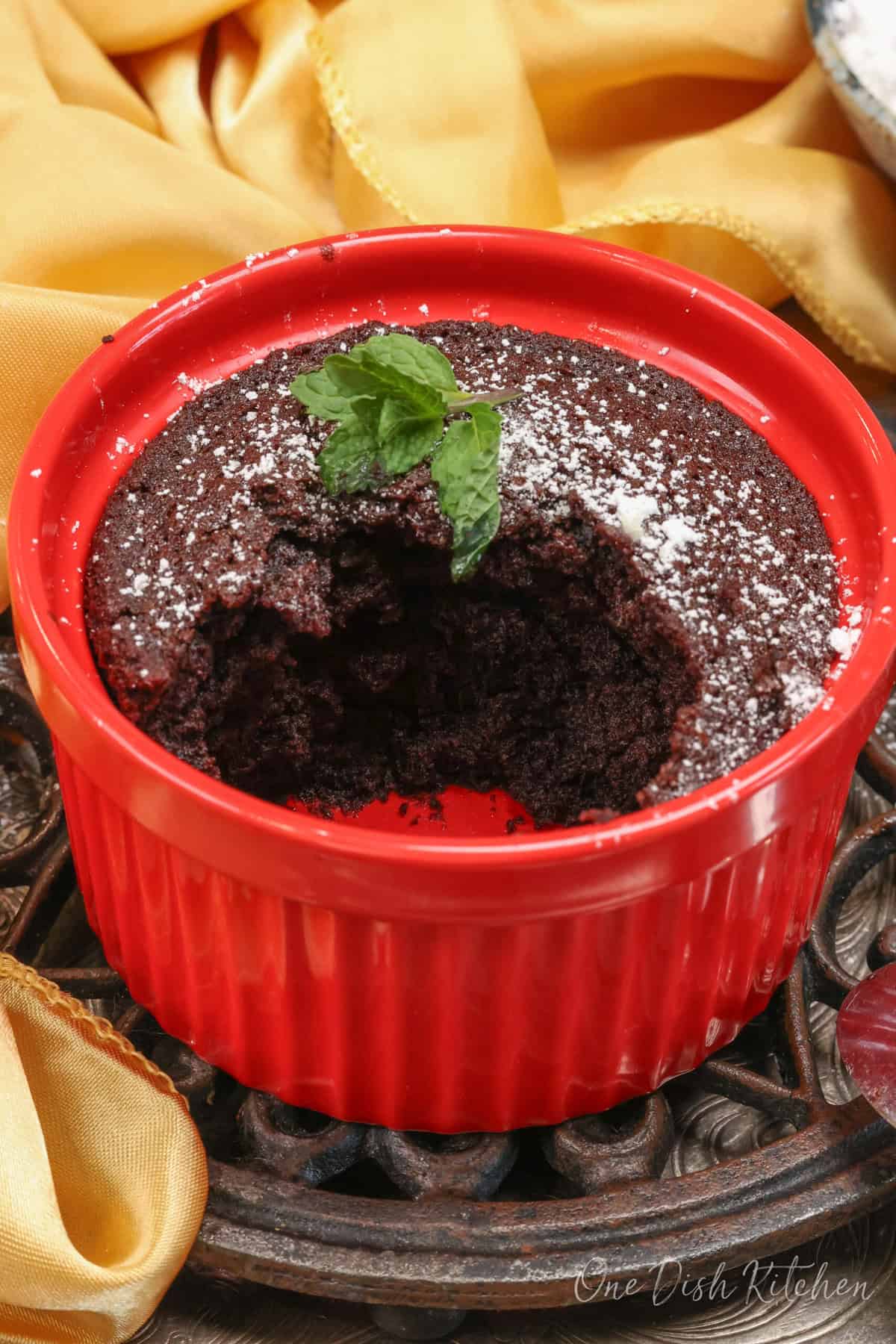 a partially eaten chocolate cake in a ramekin.