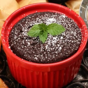 a mini chocolate cake topped with powdered sugar and fresh mint.