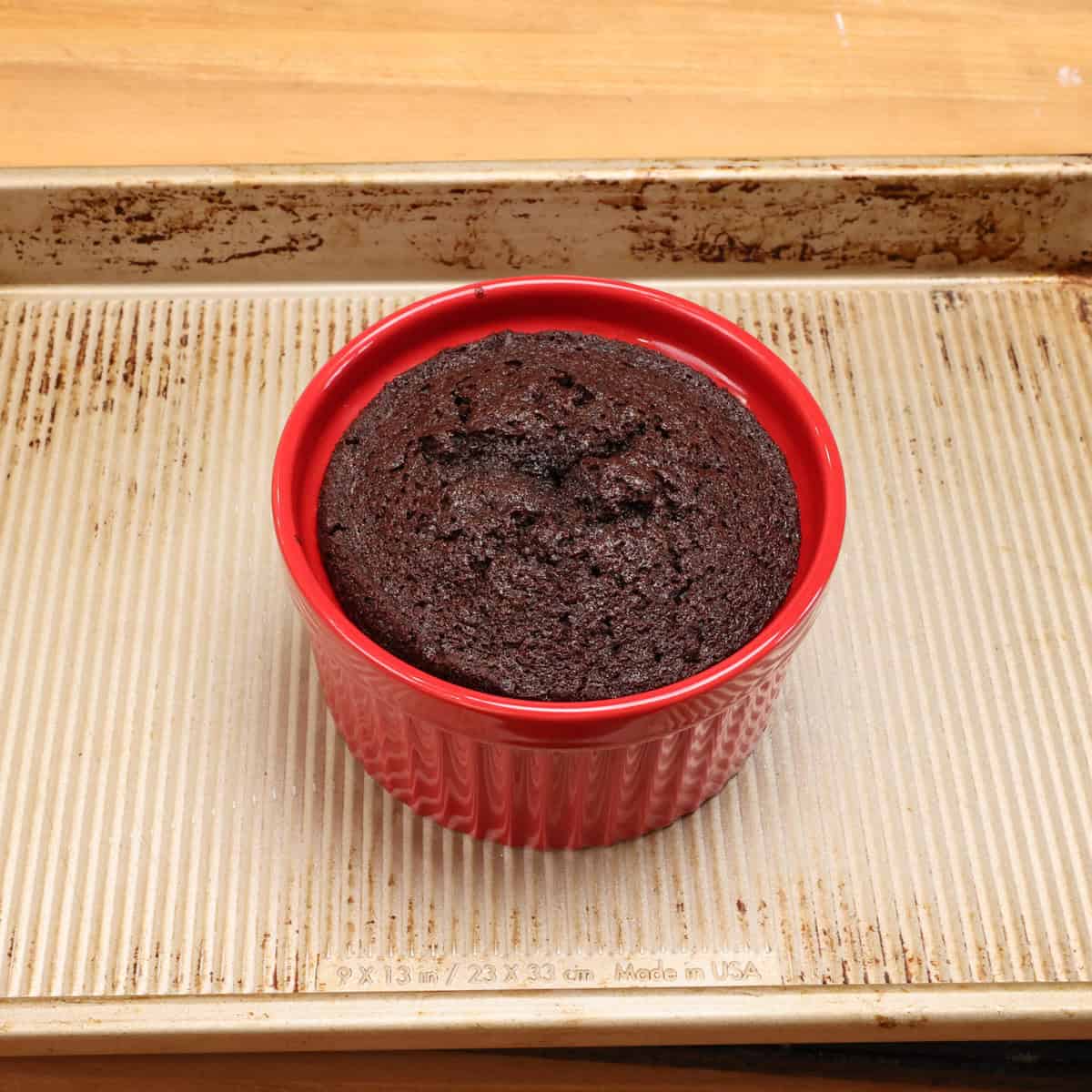 a small chocolate cake in a red ramekin.