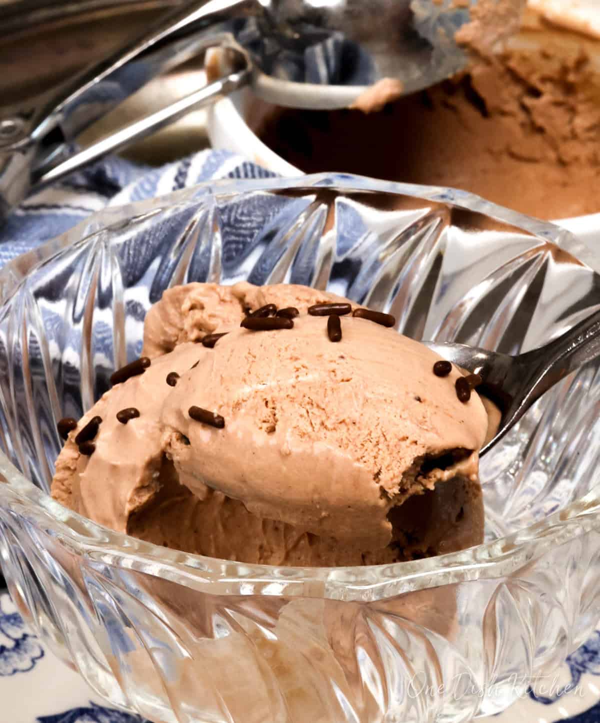 a bowl of chocolate ice cream with a spoon on the side.