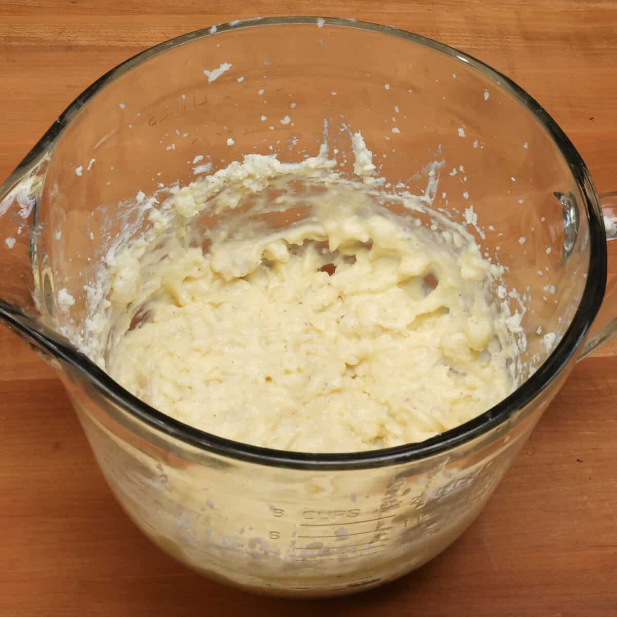 mashed potatoes with butter and egg in a mixing bowl.