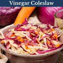 a bowl filled with coleslaw next to a brown napkin, cabbage, onions, and carrots.