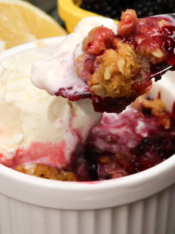 blackberry crisp in a small bowl with vanilla ice cream.