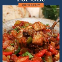 a bowl of caponata with a spoon on the side of the bowl.