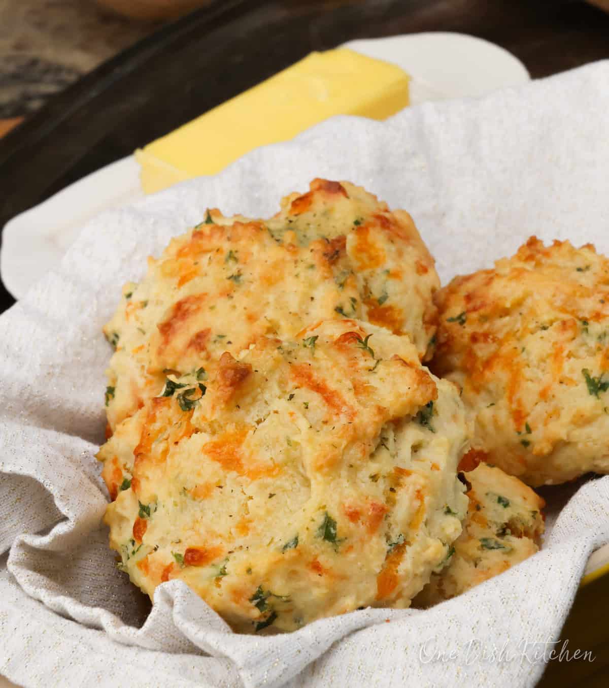 four cheddar biscuits in a bread basket.