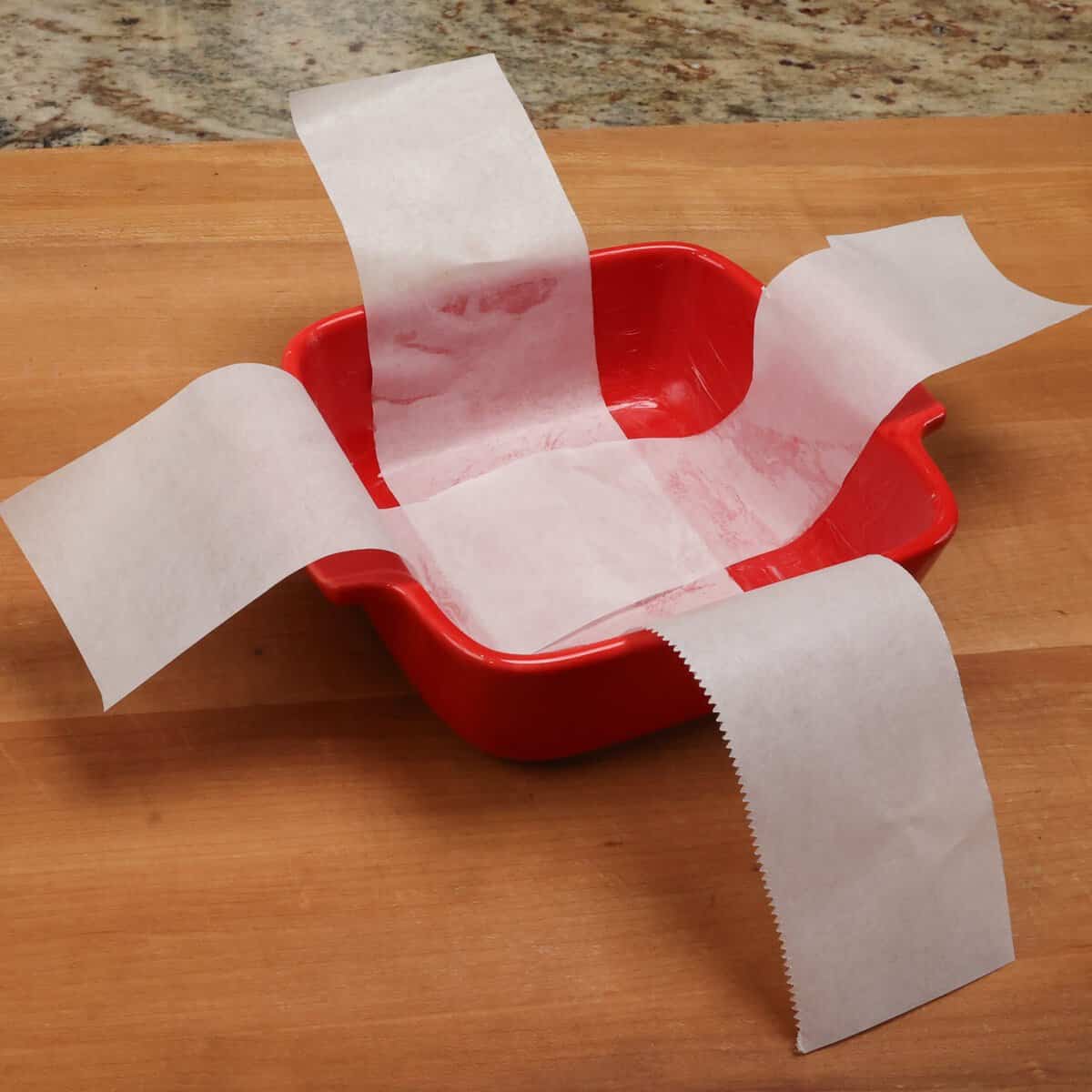 two strips of parchment paper lining a small baking dish.