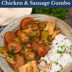 a bowl of gumbo with chicken and sausage next to white rice.