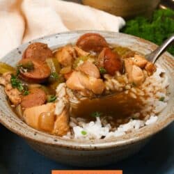 chicken and sausage gumbo in a brown bowl with a spoon on the side.