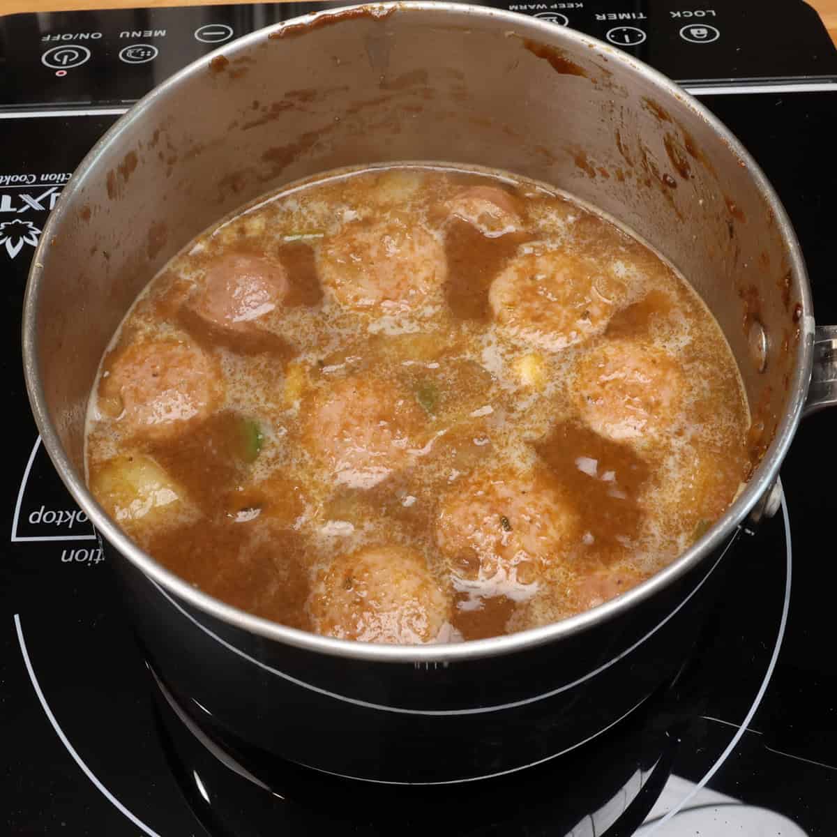 sausage gumbo simmering in a pot.