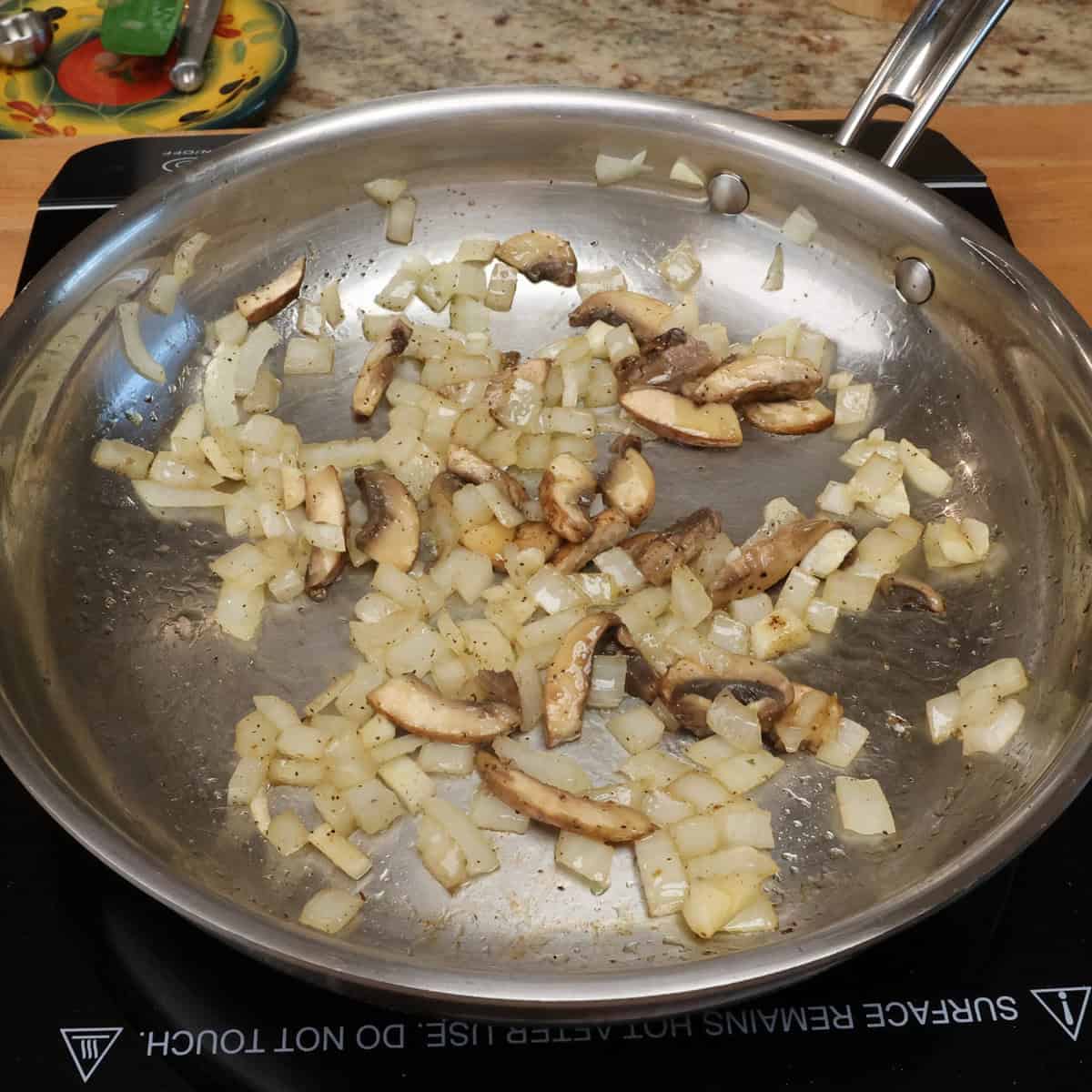 onions and garlic cooking in a skillet.