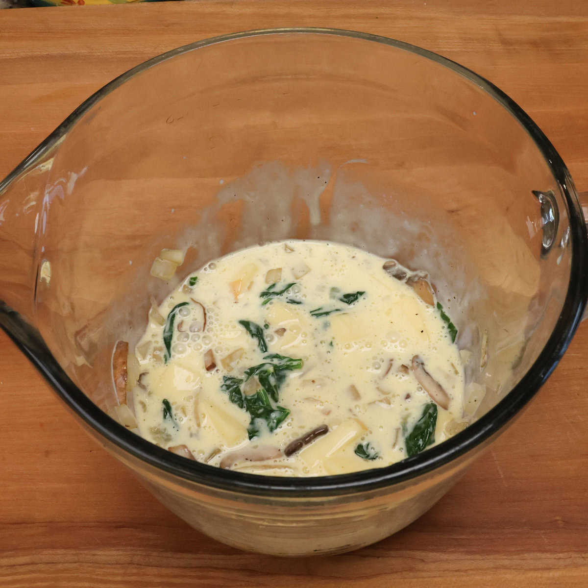 spinach mushroom quiche batter in a mixing bowl.